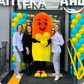 Команда АНЦ з маскотом біля входу в аптеку